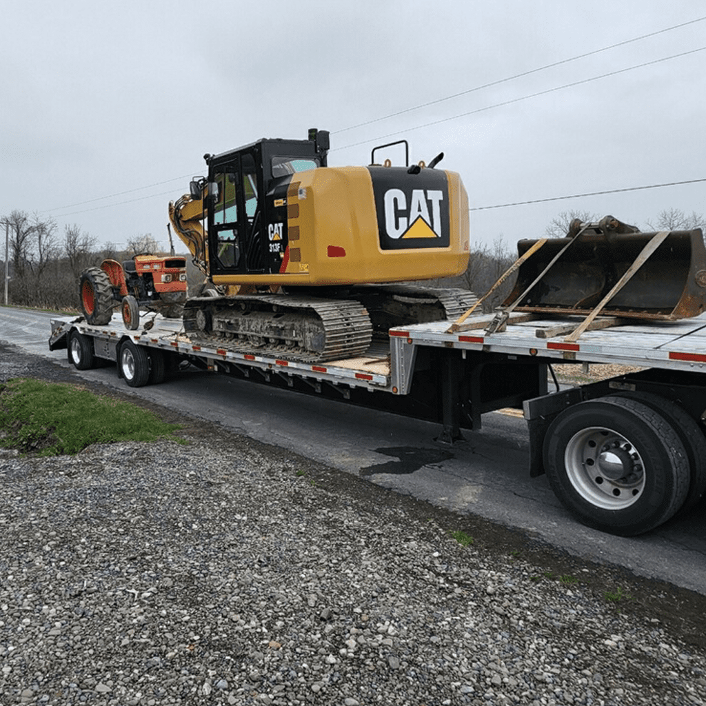 Flatbed truck carrying a heavy vehicle.